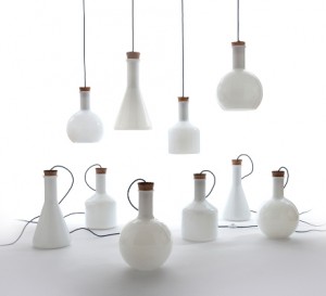luce design le lampade disegnate da Benjamin Hubert  realizzate in vetro soffiato hanno l'aspetto di bottiglie  luminose chiuse da un turacciolo di sughero