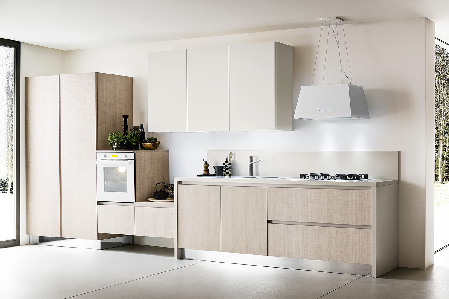 Cucina senza maniglie Six 05 con forno e fuochi estetica vetro bianco abbinati alla cappa di design a soffitto. Frigorifero doppia porta da incasso.